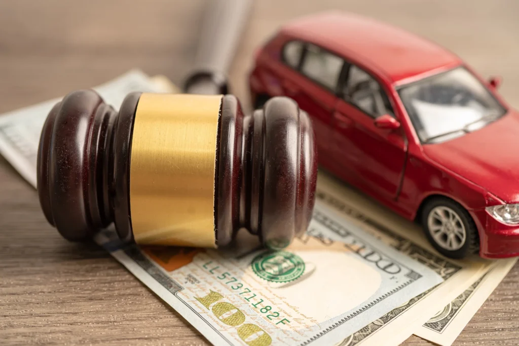 A toy car and a gavel on top of money.