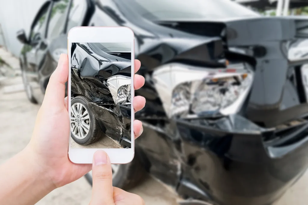 Photographing car damage after an accident with a truck.