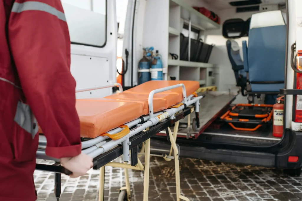 EMTs pulling a stretcher out of an ambulance.