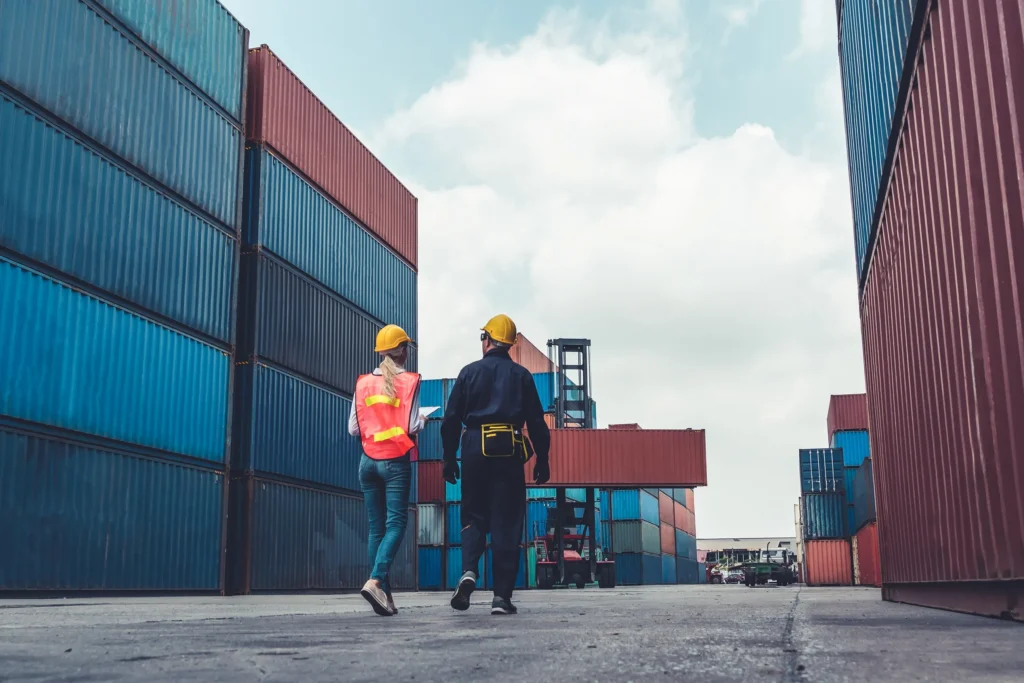 Dock workers walking between cargo.